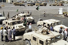 A Saudi Arabian High-Mobility Multipurpose Wheeled Vehicles (HMMWV) wait for food stores to be off-loaded at the Mogadishu seaport. The food will be provided to the Somali people.