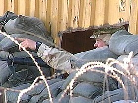 A U.S. soldier at the main entrance to the Port of Mogadishu points to identify a sniper's possible firing position
